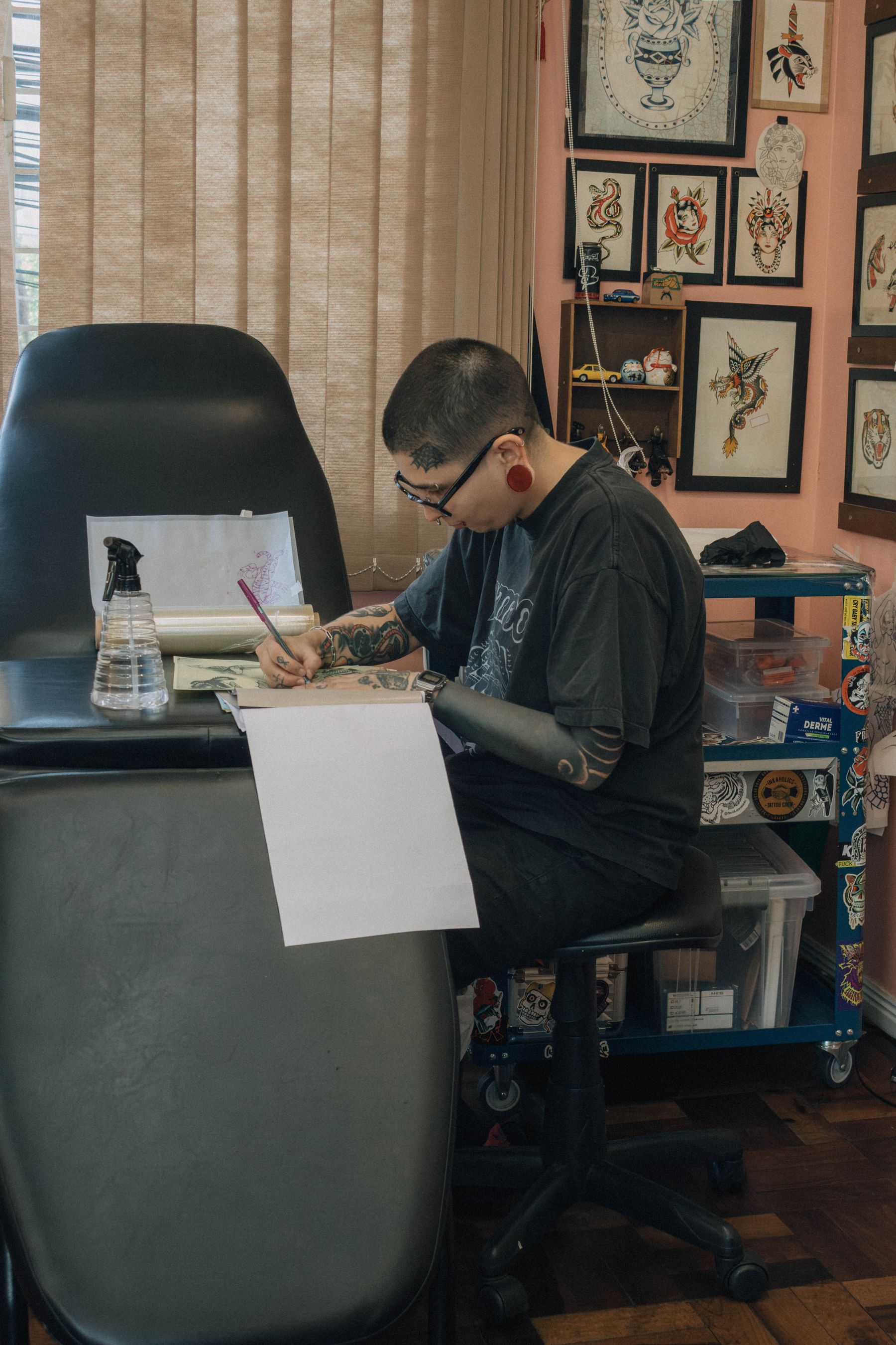 Tattoo artist drawing at a studio workstation