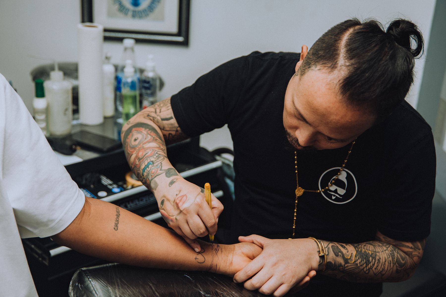 Tattoo artist working with a client in a studio