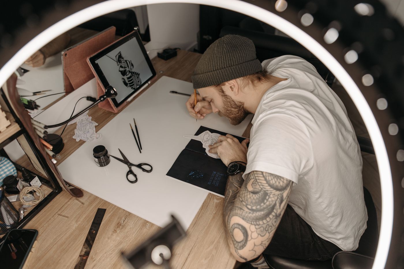 Tattoo artist developing an original design at a worktable